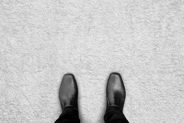 Image of businessman's shoes standing on clean carpet thanks to commercial carpet cleaning in Sandy, UT