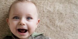 Happy carpet baby Laughing baby boy lying on a carpet
