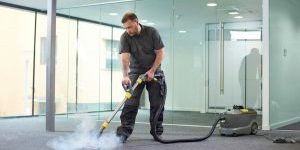 steam cleaning the office carpet a male cleaning contractor steam cleans an office carpet in a empty office in between tenants.